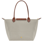 Beige tote bag with brown handles on a white background