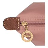 Close-up of a pink bag with a gold zipper pull featuring the Longchamp logo.